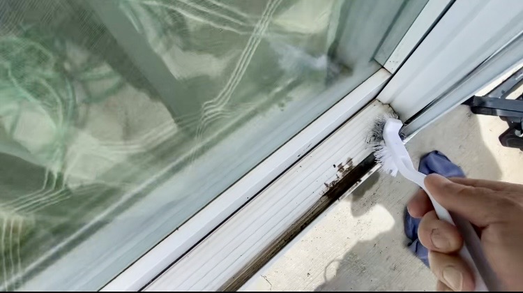 Grimy window track detail before cleaning