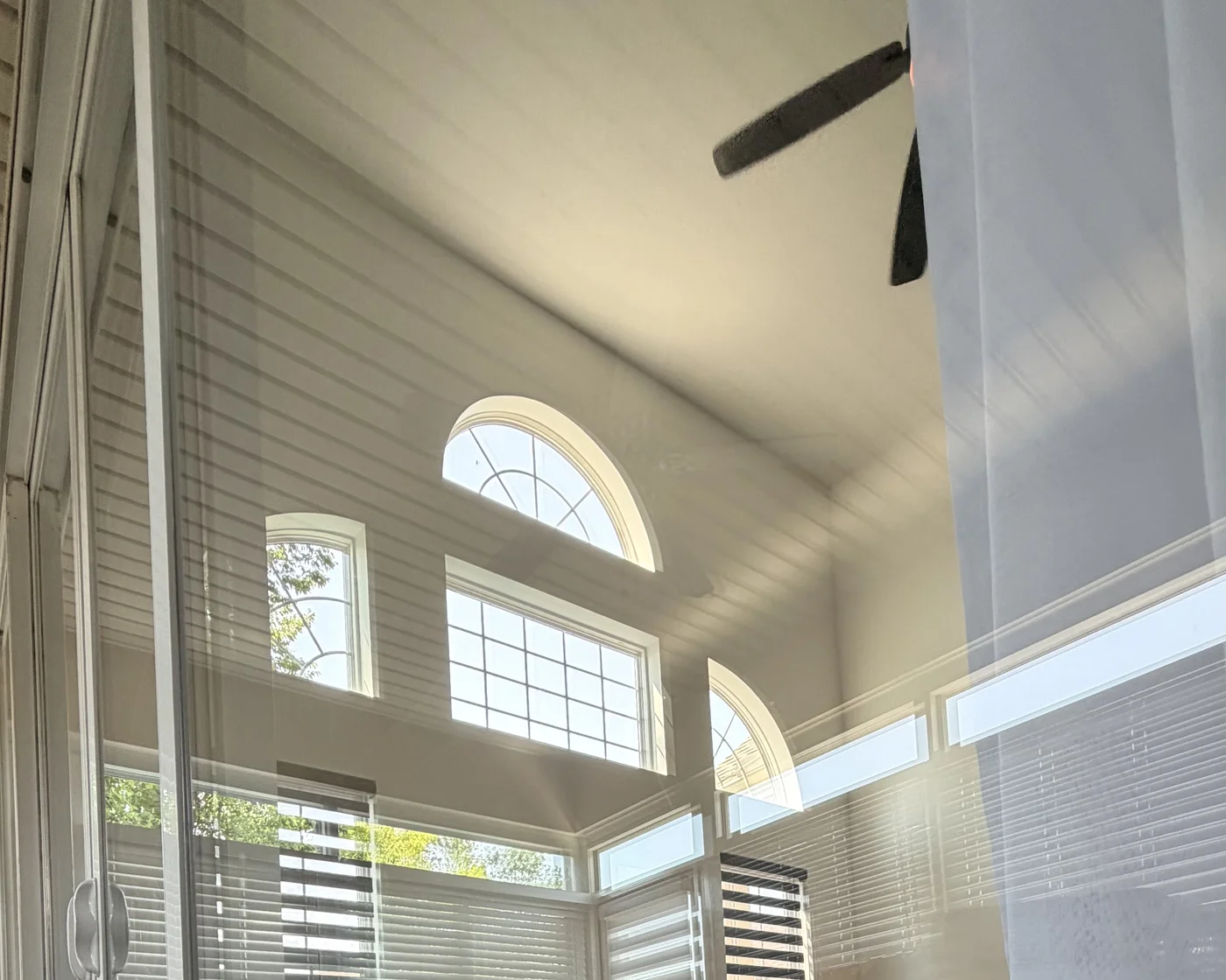 Reflection in cleaned glass showing tall interior windows and high arched glass