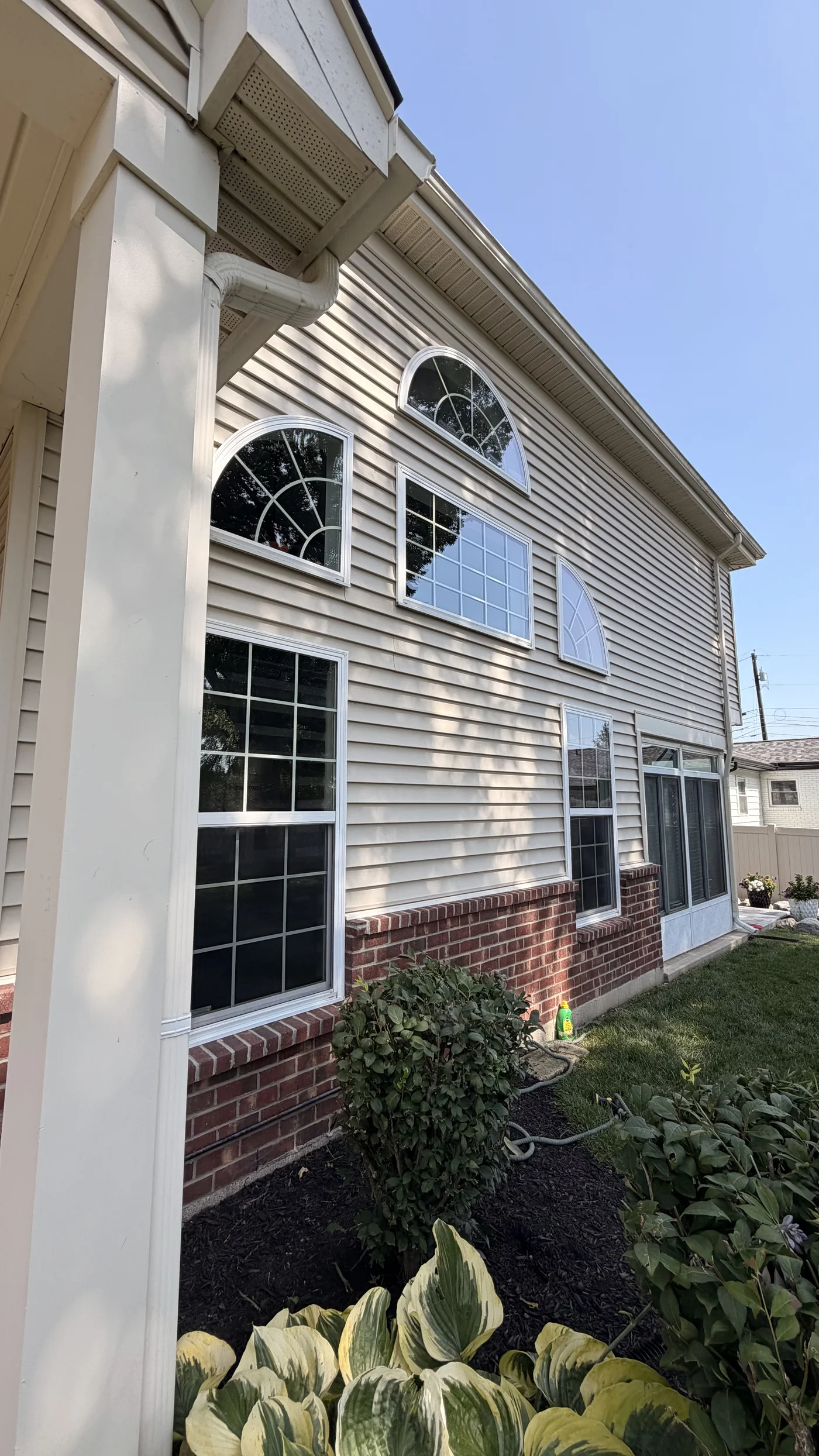 Exterior view of high arched, picture and transom windows after cleaning