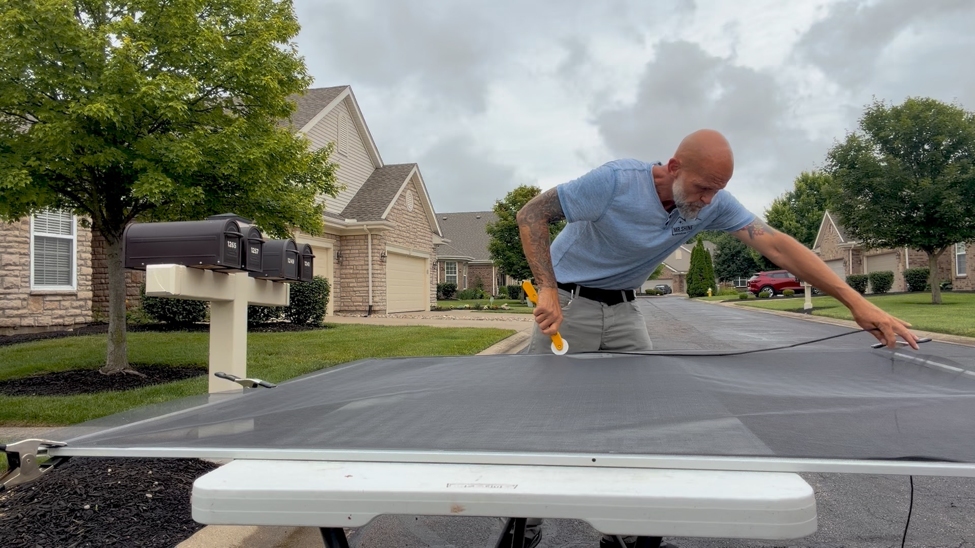 Shawn rolling spline into a large screen frame in Centerville, Ohio